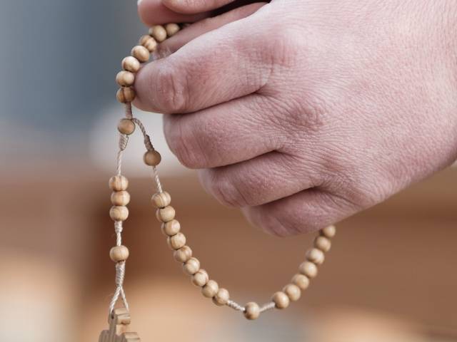 Kinder und Jugendliche basteln einen Rosenkranz